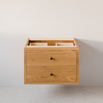 The Double Drawer Vanity in Cherry by Krovel Furniture Co. is a custom-size floating cabinet with hardwood veneer, two drawers with black knobs, and two open top compartments for sinks, mounted on a light wall above a tiled floor.