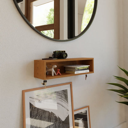 The Krovel Entryway Organizer in Cherry elegantly holds a camera and decorative items under a large round mirror. Framed artwork leans stylishly below, while a potted plant adorns the right side.