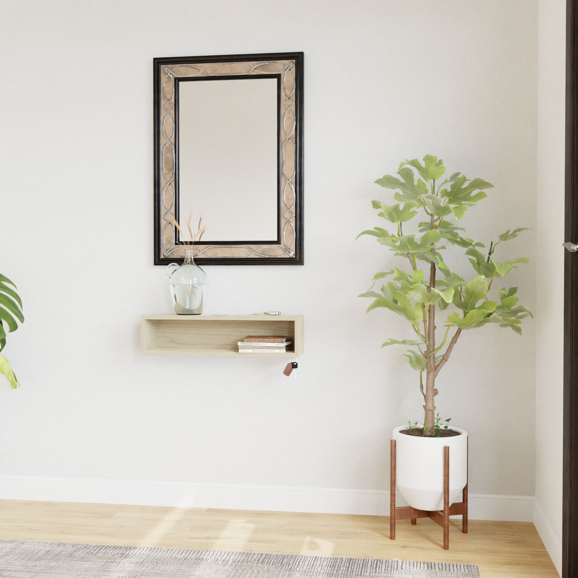A minimalist interior showcases a wall-mounted mirror with a French-cleat above Krovel's Entryway Organizer in Maple, holding a vase of dried flowers. Nearby, a tall potted plant sits on a wooden stand atop the light-colored hardwood floor.