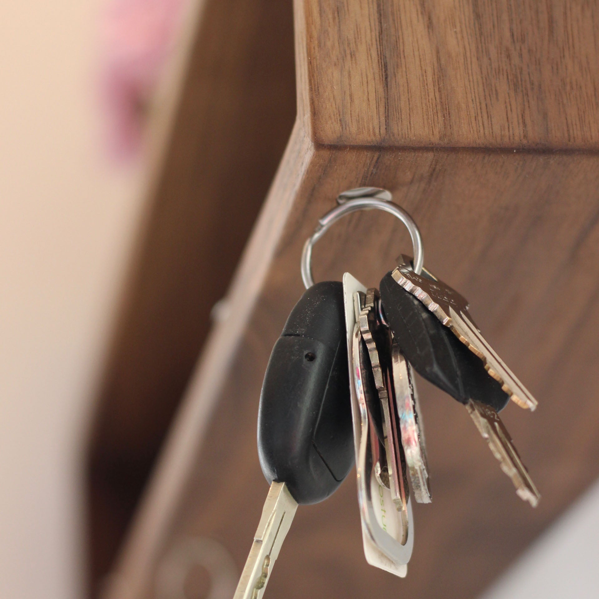 A set of keys hangs from a metal hook on the Krovel Hardwood Entryway Organizer, a handmade floating shelf.