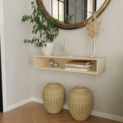 A modern entryway features a Krovel Hardwood Floating Console Table with a round mirror above, holding books, decor, a plant, and dried grasses, plus two woven baskets underneath on a herringbone wood floor.