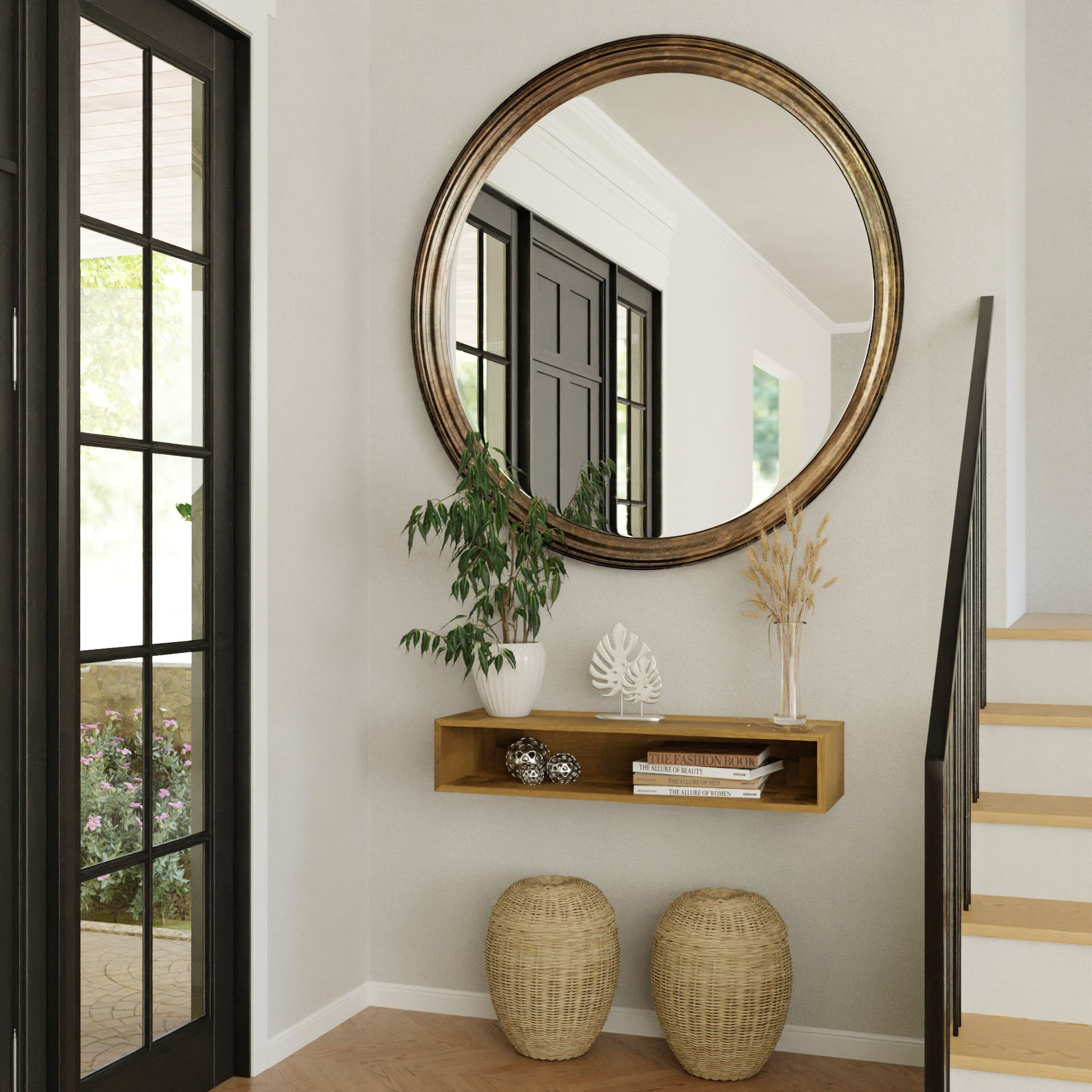 A modern entryway features the Krovel Hardwood Floating Console Table topped with decor and a potted plant, large round mirror above, and two woven baskets below, all positioned near the staircase and black-framed glass door.