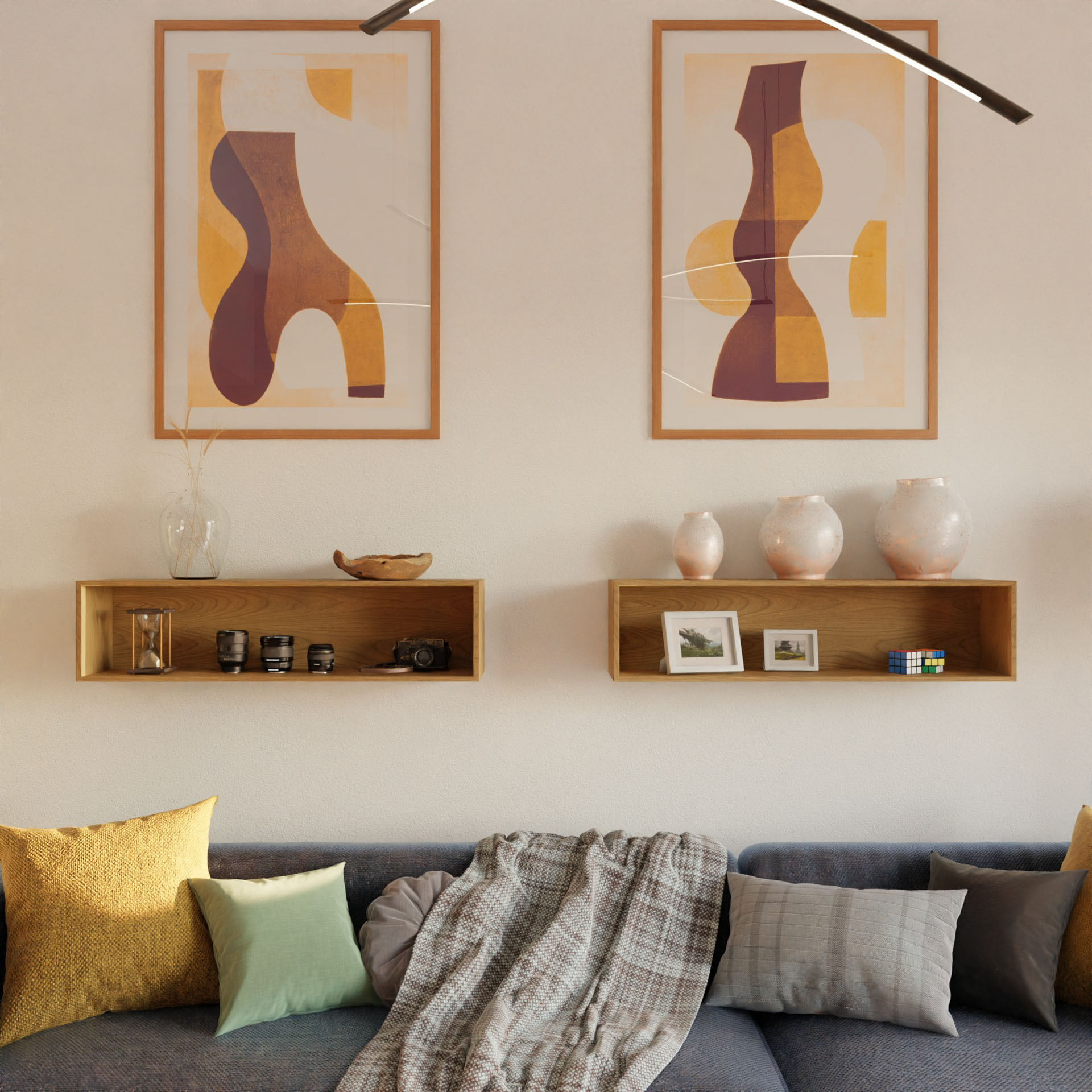 A modern living room features a gray sofa, colorful pillows, and a plaid throw. Above, Krovel Hardwood Floating Display Cases showcase vases, framed photos, and decor, while two earthy abstract art prints hang on the wall.
