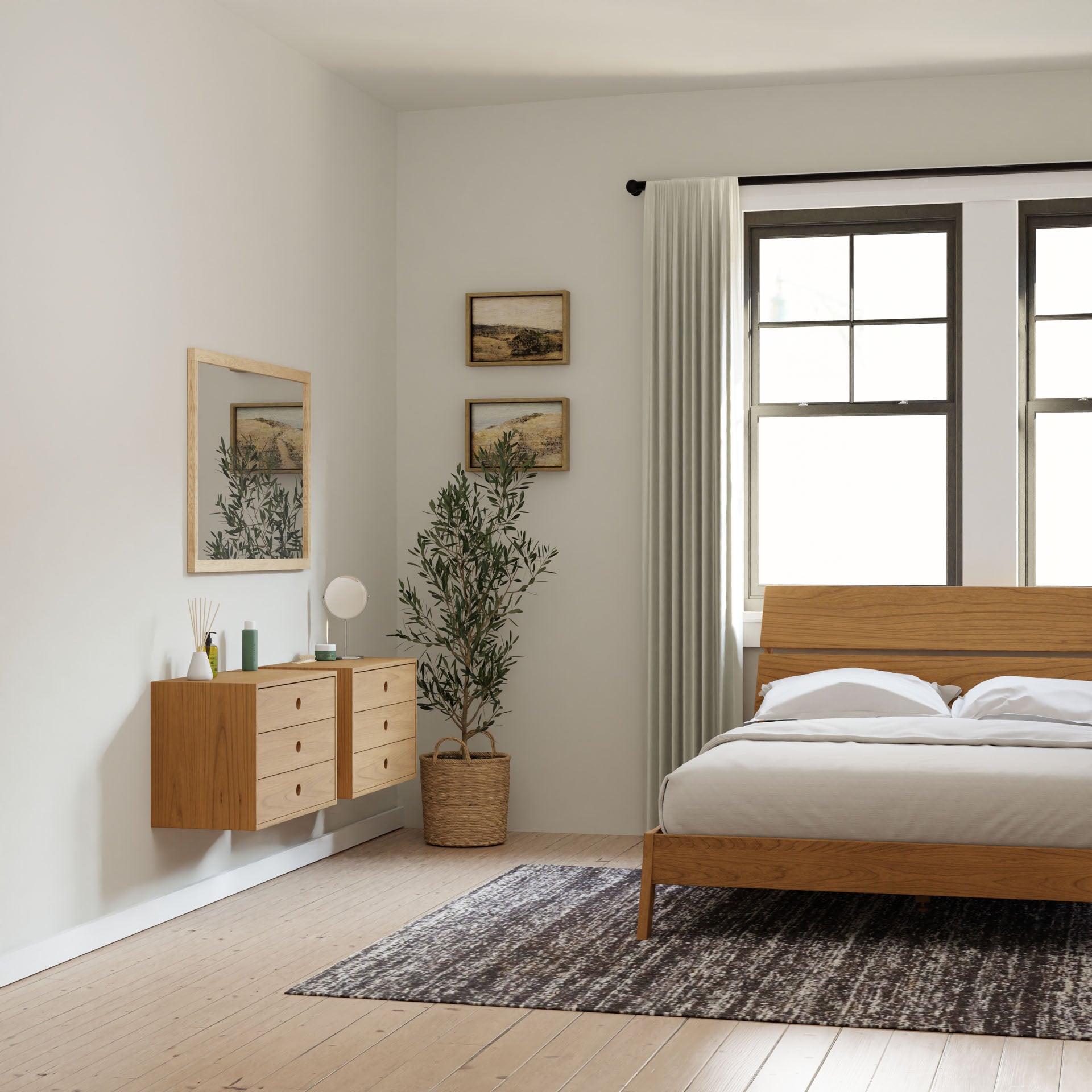 A minimalist bedroom features light-colored wood flooring and a wooden bed. A large leafy plant in a basket sits beside the bed. Krovel's Floating Dresser in Cherry, paired with a mirror, is mounted on the wall with two framed pictures above it. Light curtains decorate the window.