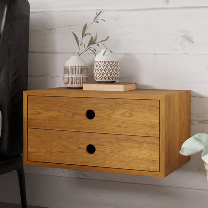 The Floating Nightstand in Cherry by Krovel is a beautifully crafted wall-mounted cabinet made from solid Maple, featuring two drawers with round handles. Adding charm to the setup are decorative vases with geometric patterns and a small sprig of greenery displayed on top. A partially visible black chair complements this elegant piece, which is securely mounted using a French cleat system.