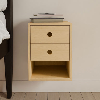 The Krovel Hardwood Triple Floating Nightstand is a handmade solid hardwood piece with three drawers featuring circular cutout handles, an open shelf below, and space on top for books and glasses.