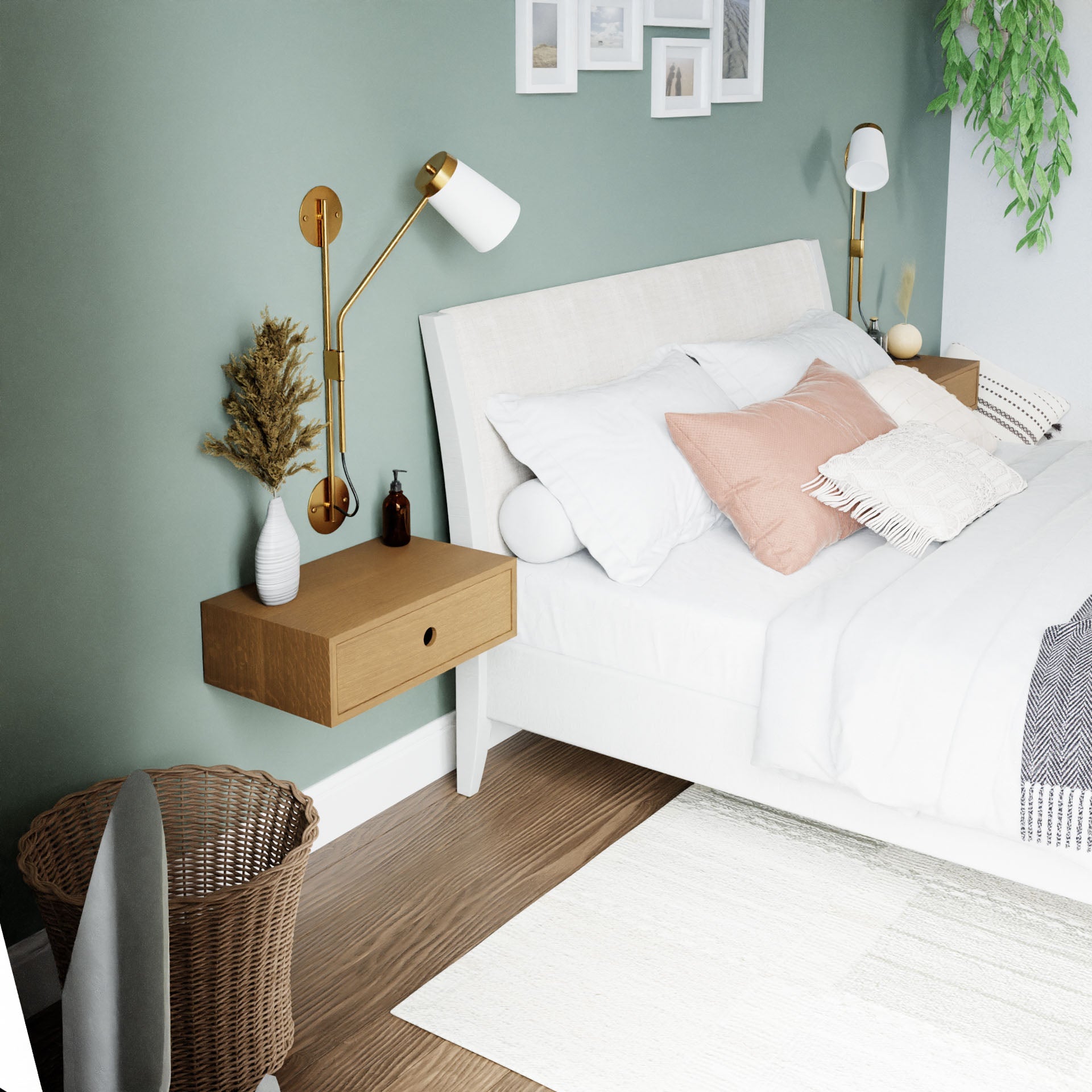 A modern bedroom showcases a white bed adorned with light blue and pink pillows, complemented by Krovel's Floating Nightstand in White Oak featuring brass lamps. A woven basket adds texture, and a green accent wall displays framed pictures. A plant brings in greenery, while a neutral rug enhances the wooden floor. 