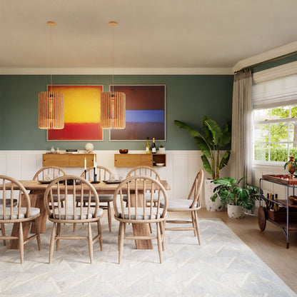A modern dining room spotlights a sleek American Cherry table with six chairs. Two abstract paintings enliven the dark green wall. Pendant lights, plants, Krovel's Floating Storage Cabinet in Cherry with decor and wine bottles, and a window with curtains complete the setting.