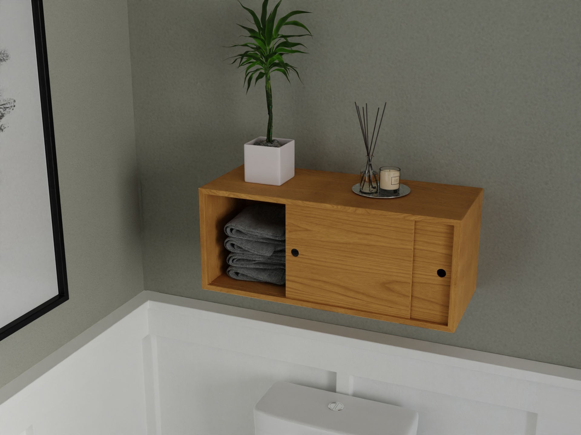 The Krovel Floating Storage Cabinet in Cherry, mounted with a French cleat above a white toilet, displays stacked gray towels. A small potted plant and a tray of candles and reed diffusers sit on top, against gray and white walls.