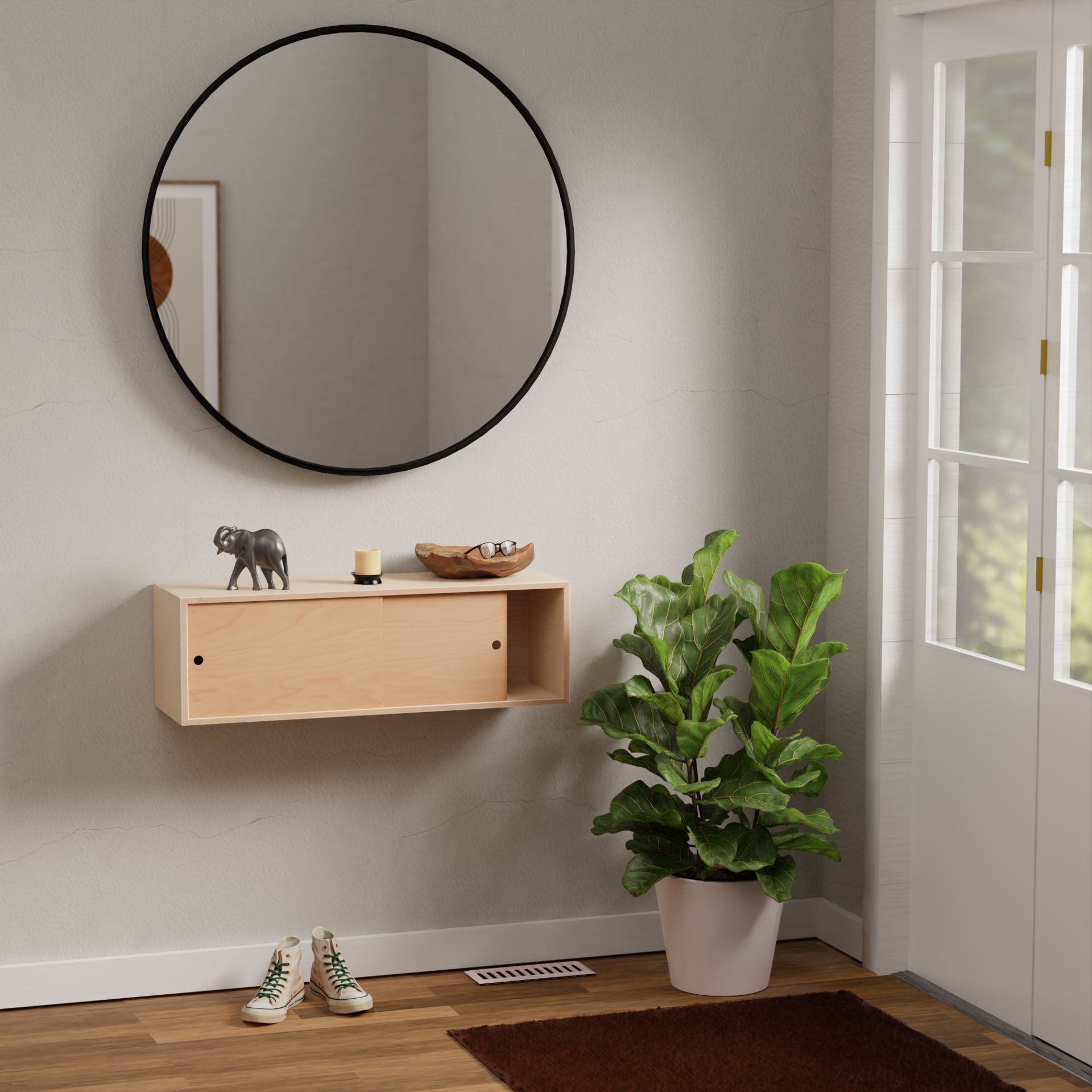 A minimalist entryway showcases a round mirror above a wooden console with an elephant figurine and candle. Nearby, the Krovel Floating Storage Cabinet in Maple offers sleek organization. A potted plant adds greenery while glass doors allow natural light onto a brown mat and shoes below.