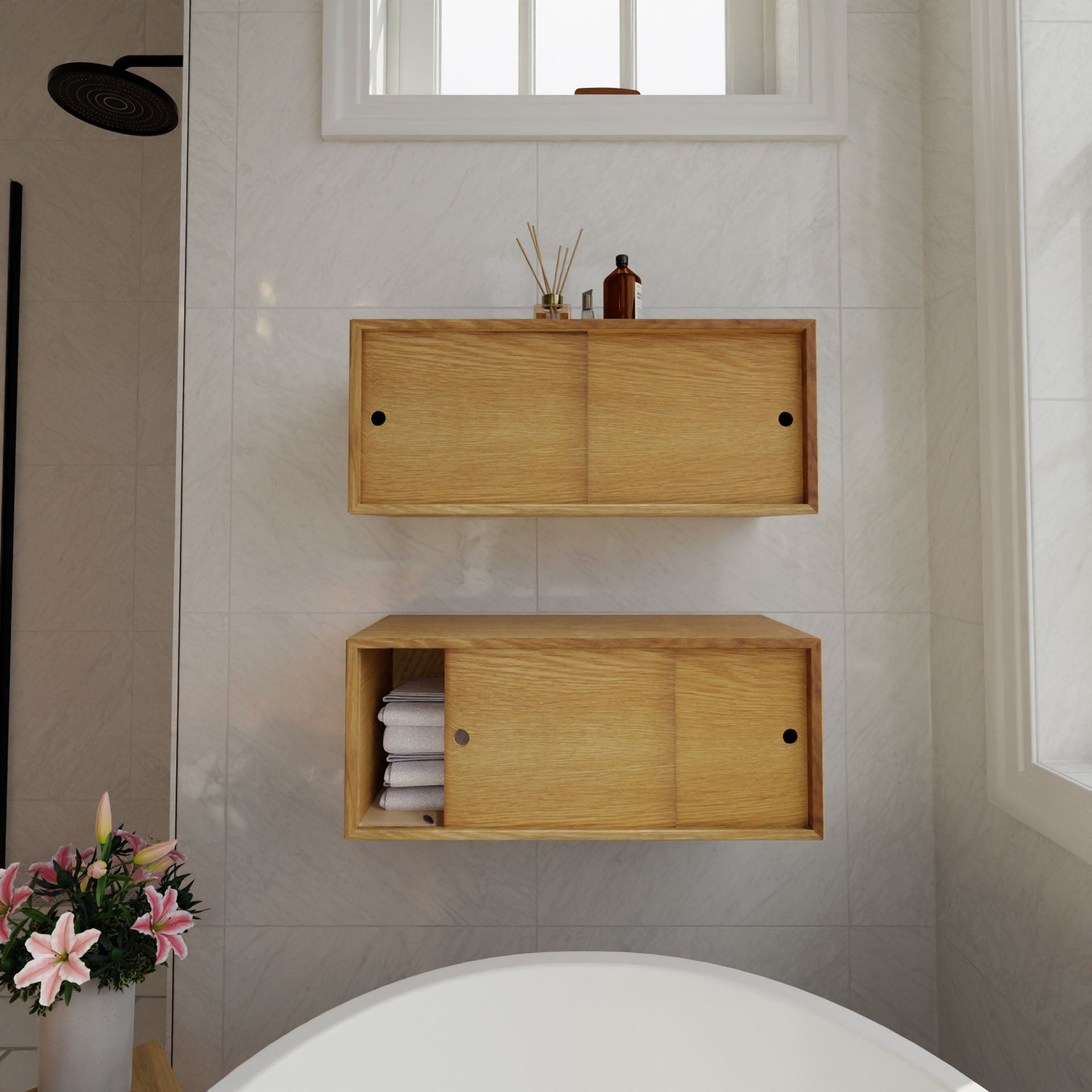 Modern bathroom interior featuring Krovel's Floating Storage Cabinet in White Oak on a marble wall. In the foreground is a circular bathtub with a nearby vase of pink flowers. A white oak-trimmed window adds elegance above, complemented by a showerhead to the left.