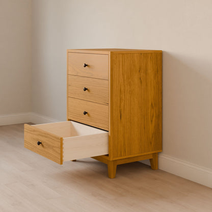 A handmade Four Drawer Dresser in Cherry by Krovel Furniture Co. stands against a light-colored wall on a wooden floor. The open lower drawer reveals the interior, showcasing minimalist design, sustainable construction, and sleek black knobs.