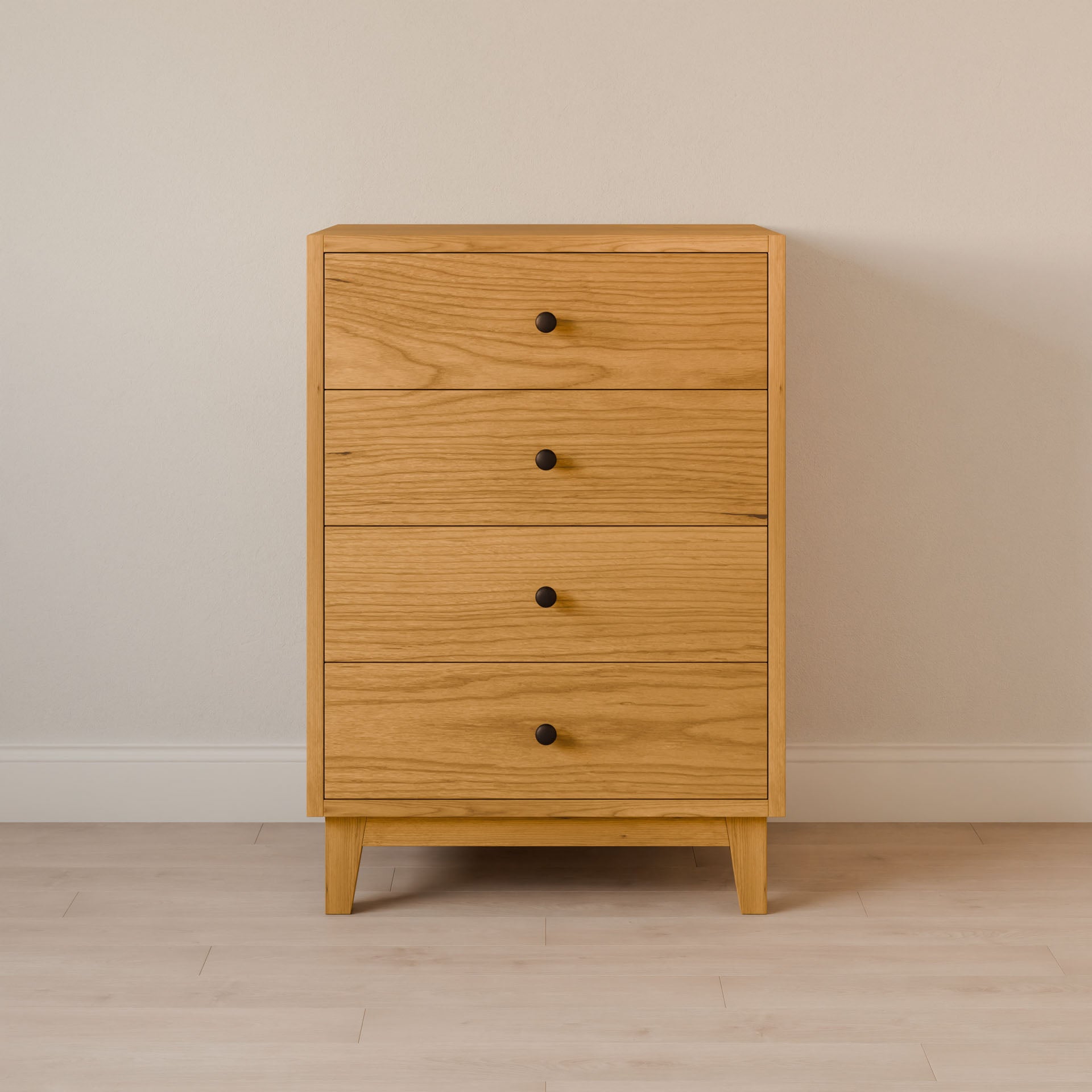 The Four Drawer Dresser in Cherry by Krovel Furniture Co. features four spacious drawers with round black knobs, standing elegantly against a beige wall on a light wooden floor—a sustainable furniture choice.