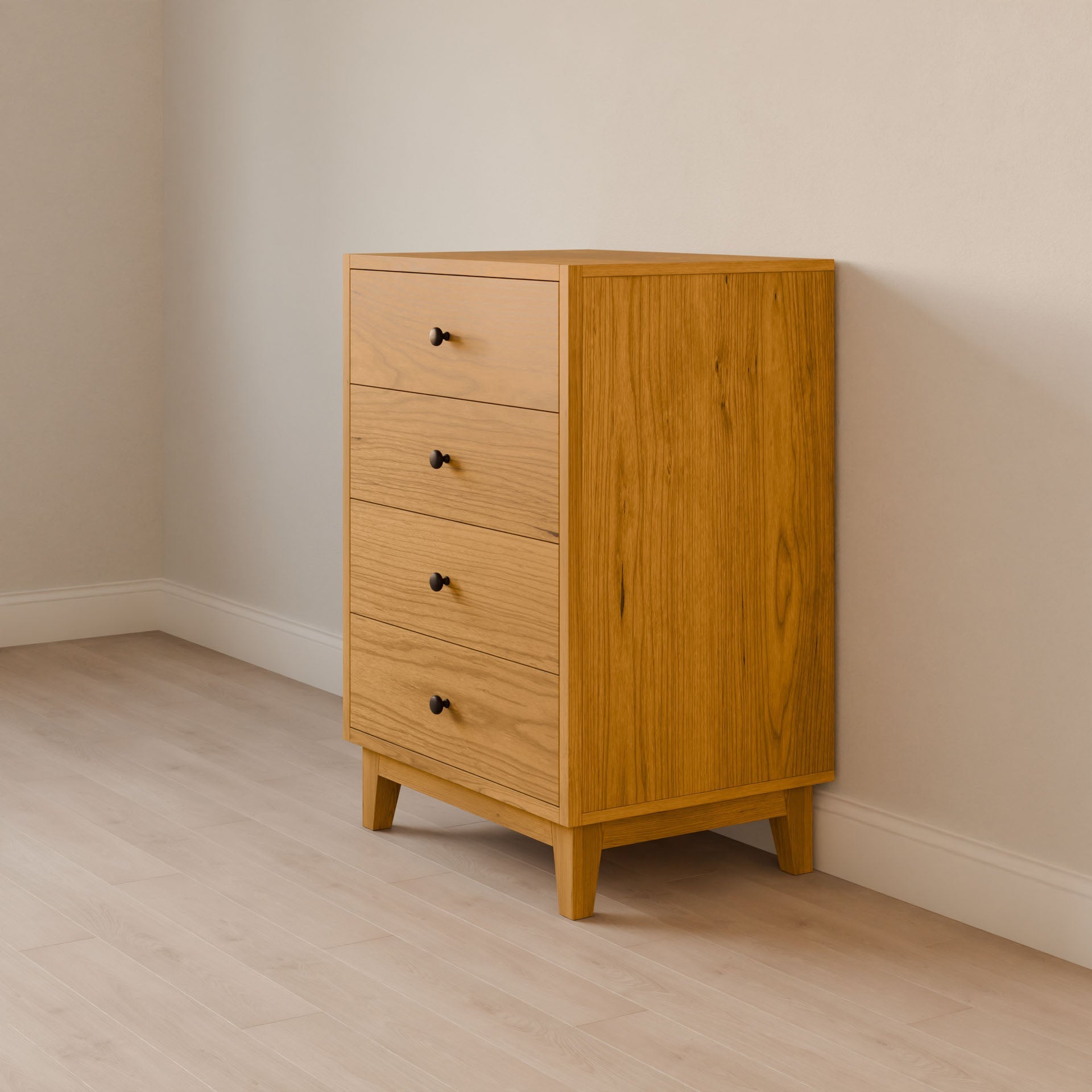 The Four Drawer Dresser in Cherry by Krovel Furniture Co. features a handmade solid wood build with four drawers and black knobs, placed against a light wall and floor, showcasing a love for sustainable furniture design.