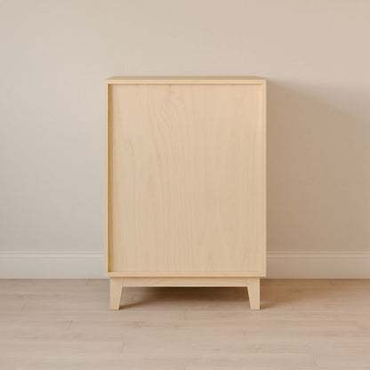 The Four Drawer Dresser in Maple from Krovel Furniture Co. stands against a beige wall, showcasing its minimalist design, tapered legs, and smooth texture. Crafted with sustainable techniques, this premium dressers light finish complements the light-colored floor, highlighting its clean lines.