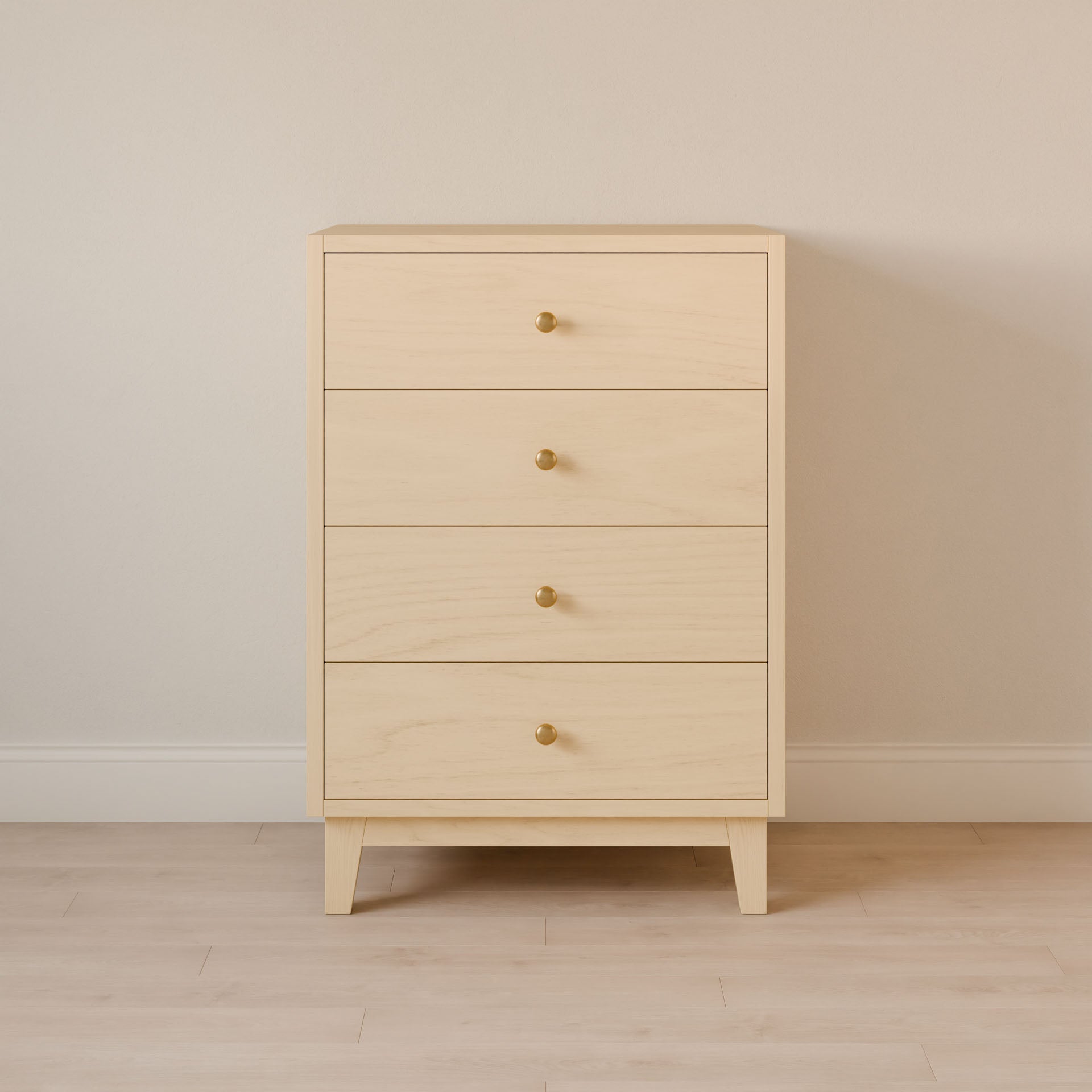 The Four Drawer Dresser in Maple from Krovel Furniture Co. stands against a neutral wall on a light wood floor, featuring a minimalist design with clean lines and sustainable construction. Each drawer is adorned with a round gold knob, emphasizing the handmade elegance of this piece.