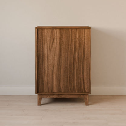 The Krovel Furniture Co. Maine Made Four Drawer Dresser, handcrafted in Portland, Maine, showcases a minimalist solid wood design with a smooth natural finish and clean lines, standing against a light wall and floor without visible handles or adornments.