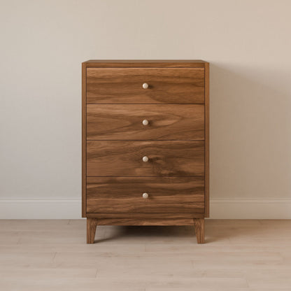 The Four Drawer Dresser in Walnut by Krovel Furniture Co., made from premium cabinet grade plywood with round white knobs, stands against a plain light-colored wall on a light wood floor.