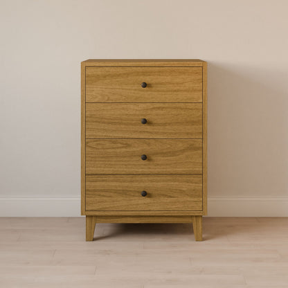 The Four Drawer Dresser in White Oak by Krovel Furniture Co. features four drawers with round black knobs and is crafted from sustainable materials, standing elegantly against a light wall on a matching wood floor.