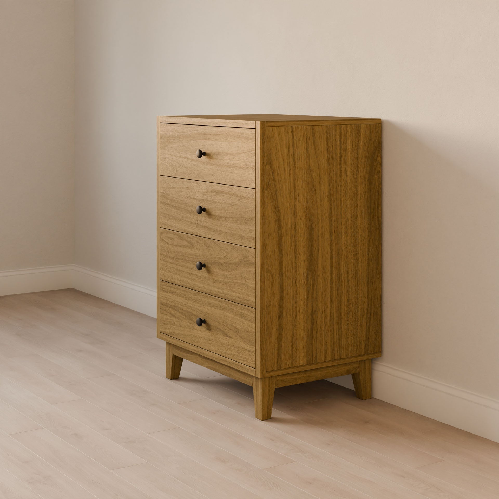 The Maine Made Four Drawer Dresser by Krovel Furniture Co. features four drawers with black knobs and stands on a light wood floor against a light wall in a minimalist room, handcrafted in Portland, Maine.