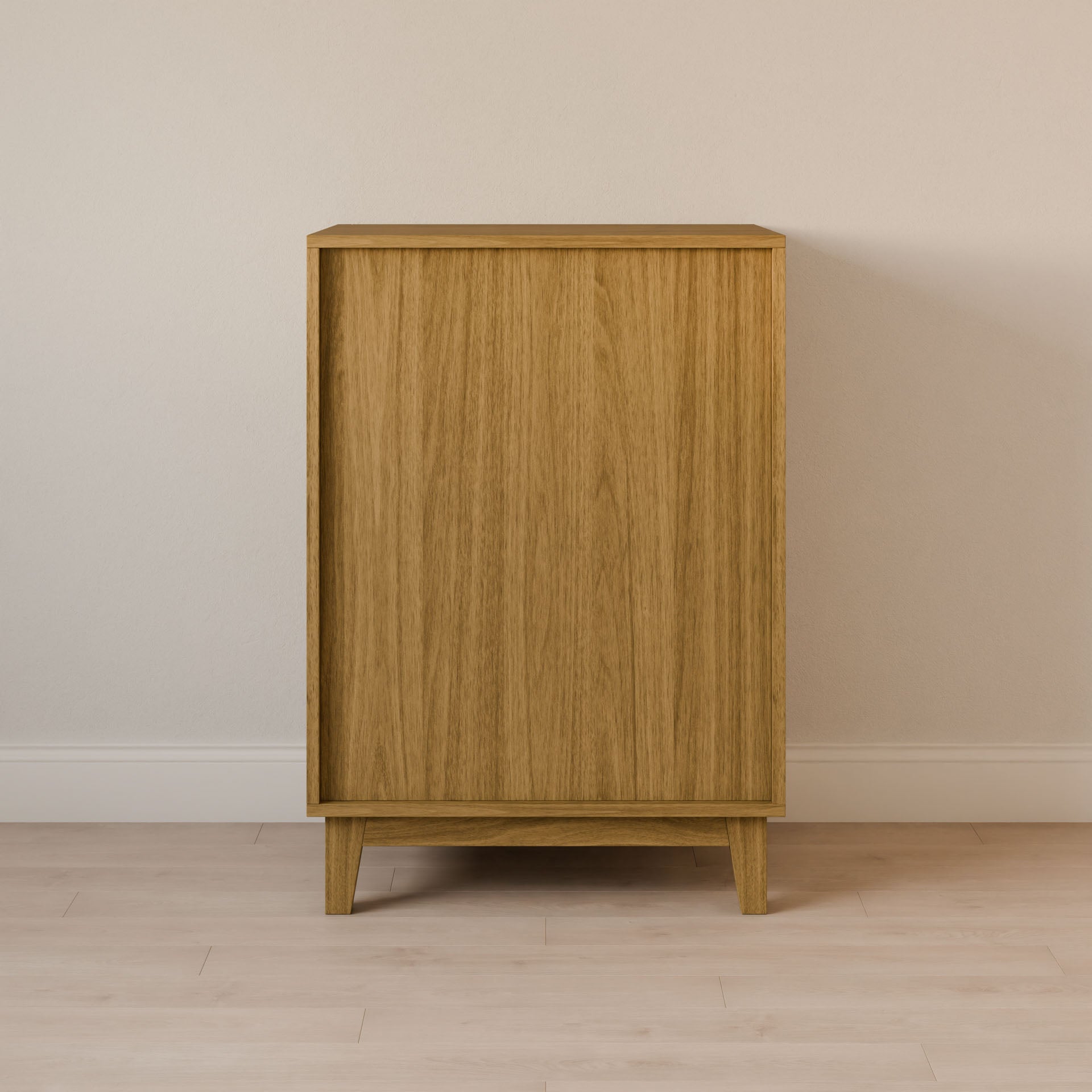 The Maine Made Four Drawer Dresser by Krovel Furniture Co., handmade in Portland, Maine, features a simple solid wood design with a plain front and four short legs, standing against a light-colored wall on a light wood floor.