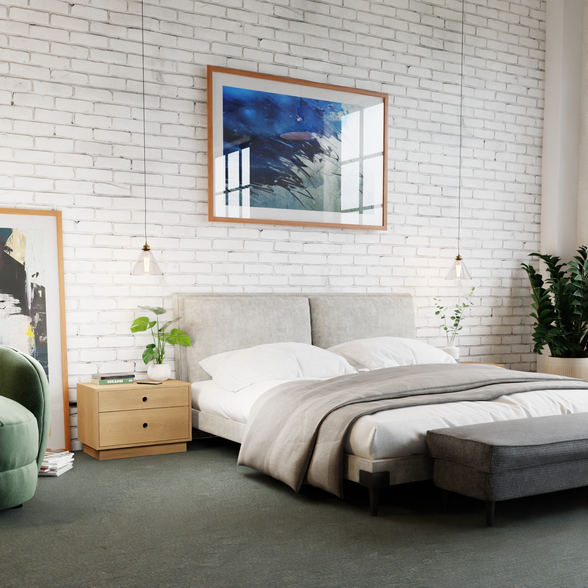 A modern bedroom with a white brick wall showcases a bed with a gray headboard and white bedding. Two small hanging lights flank floating Krovel Freestanding Nightstands in solid Hard Maple, adorned with plants. An abstract painting and green chair complete the aesthetic.