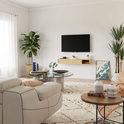 A modern living room features a wall-mounted TV over a Krovel Media Console Table in Maple. It pairs with a light sofa, round glass coffee table with books and decor. Potted plants add freshness, while a wooden side table with VOC-free polymerized linseed oil complements an abstract painting on the floor.