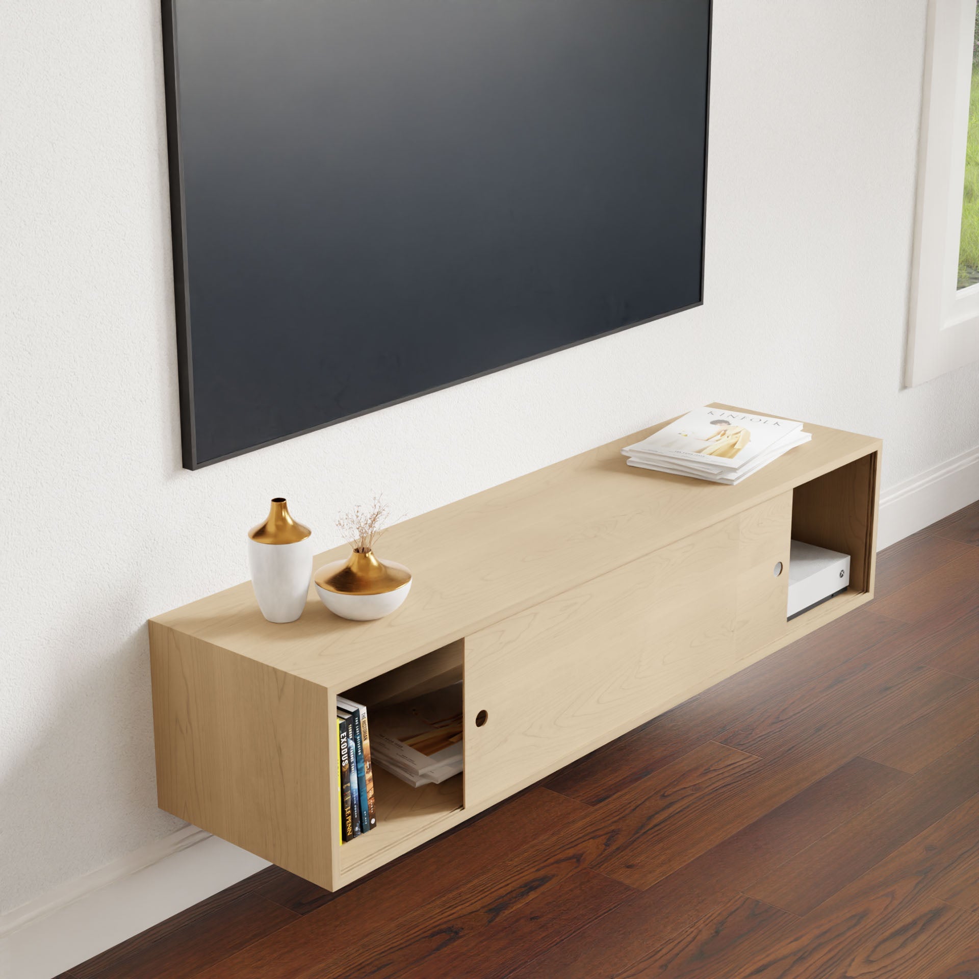 A minimalist living room showcases a mounted flat-screen TV and Krovel's Oversized Media Console Table in Maple, displaying vases and books against white walls and dark wood floors.