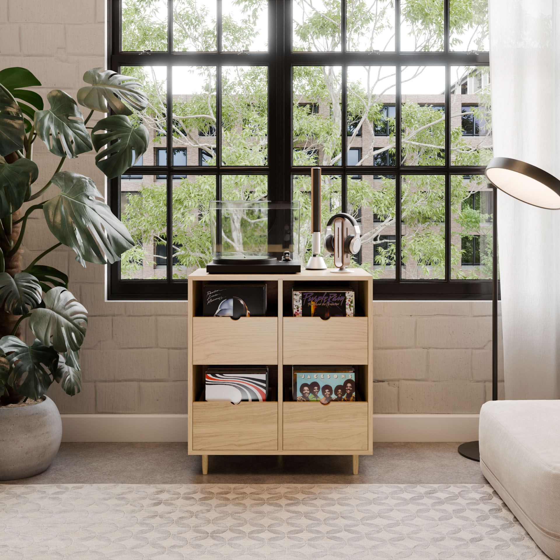 A modern living room showcases the Krovel Hardwood Four Drawer Record Credenza with records and a turntable by a large window, accented by green plants, a floor lamp, and sunlight streaming onto a patterned rug.