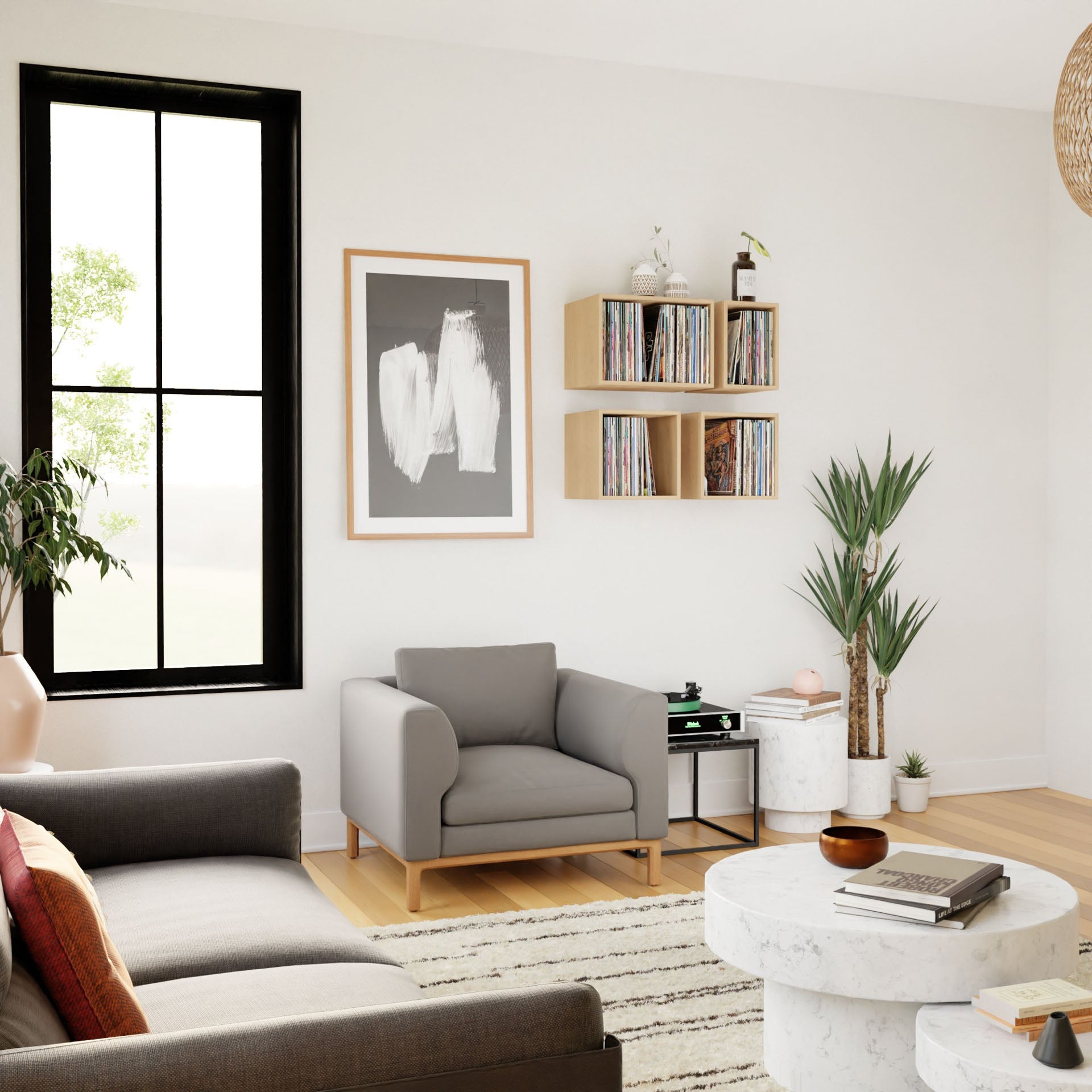 A modern living room showcases a gray armchair, sofa, round coffee table, striped rug, and light-filtering black-framed window. Krovel's Record Storage Shelves in Maple hold vinyl above an American Black Walnut accent table. A large abstract painting and two green plants enhance the decor.