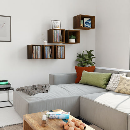 A modern living room with a gray sectional, colorful pillows, a hardwood coffee table, and a Krovel Hardwood Record Storage Shelf displaying decor, vinyl records, plus a potted plant in the corner.