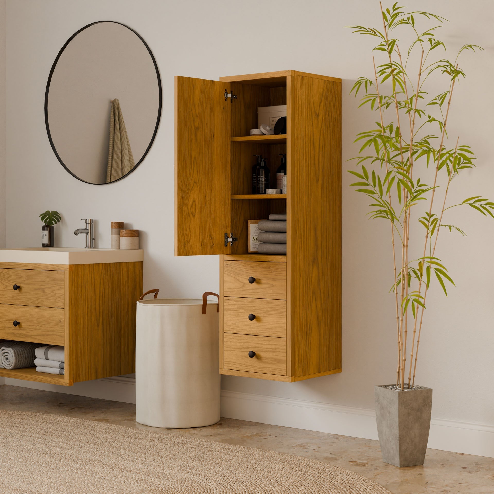 A minimalist bathroom with sustainable design includes a Triple Drawer Linen Cabinet in Cherry by Krovel Furniture Co., revealing towels and toiletries. A round mirror is above the sink with a wooden vanity, while a tall potted plant and woven rug complete the look.