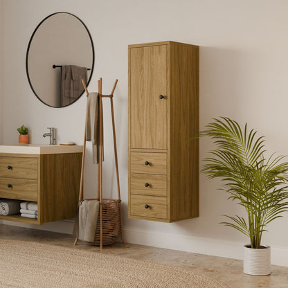 A modern bathroom features a Krovel Furniture Co. Triple Drawer Linen Cabinet in White Oak, a circular mirror, and a round sink. A tall plant is on the right, with a wooden stand for towels against the wall. Neutral tones enhance the calm and natural feel.