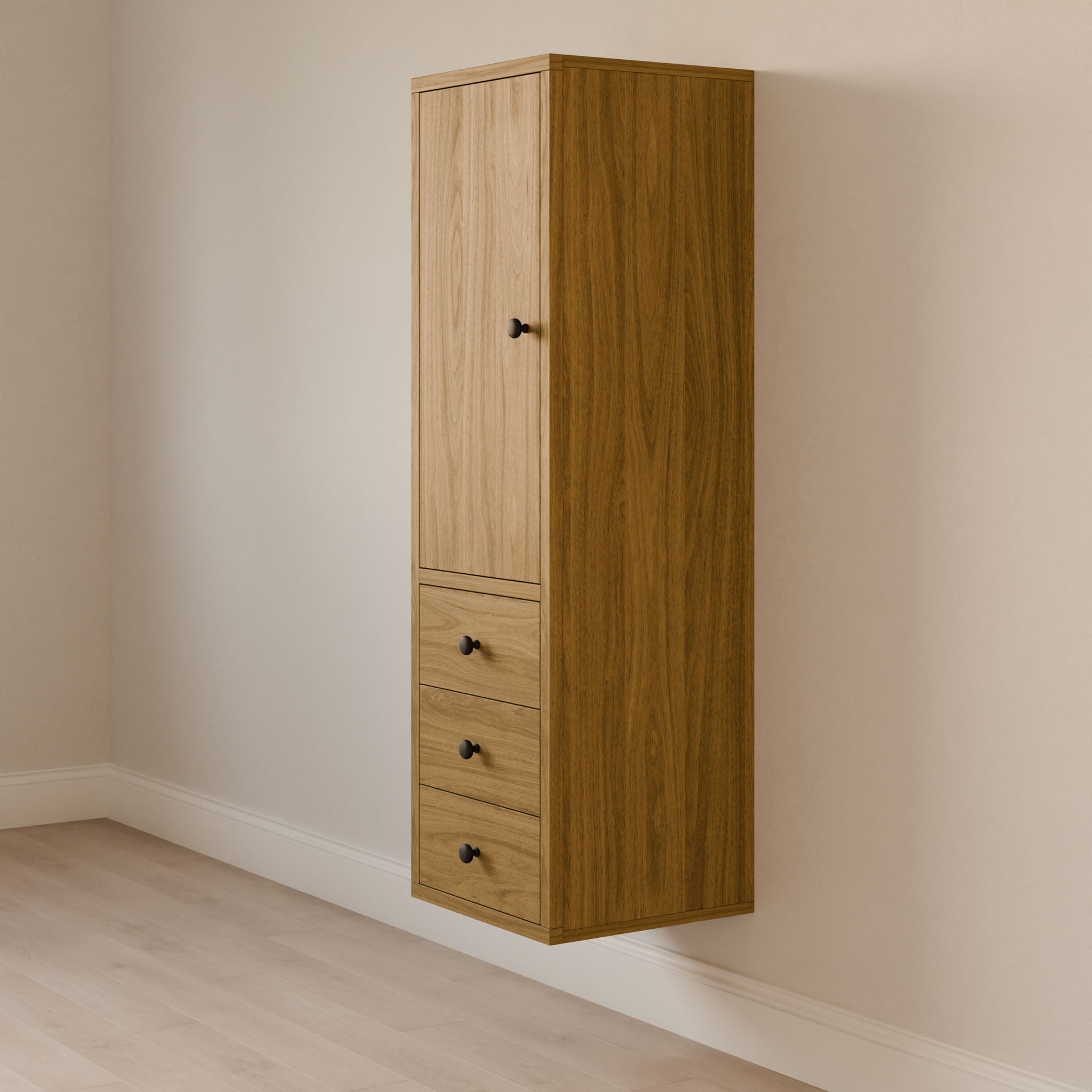 Krovel Furniture Co.s Triple Drawer Linen Cabinet in White Oak features a modern, tall design with a hardwood face frame, upper vertical panel door, and three black-knob drawers. It complements light-colored walls and wood flooring beautifully.