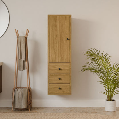 A minimalist room features the Maine Made Triple Drawer Linen Cabinet by Krovel Furniture Co., a wooden coat rack with towels, a woven basket, and a potted palm on a light floor against a beige wall.