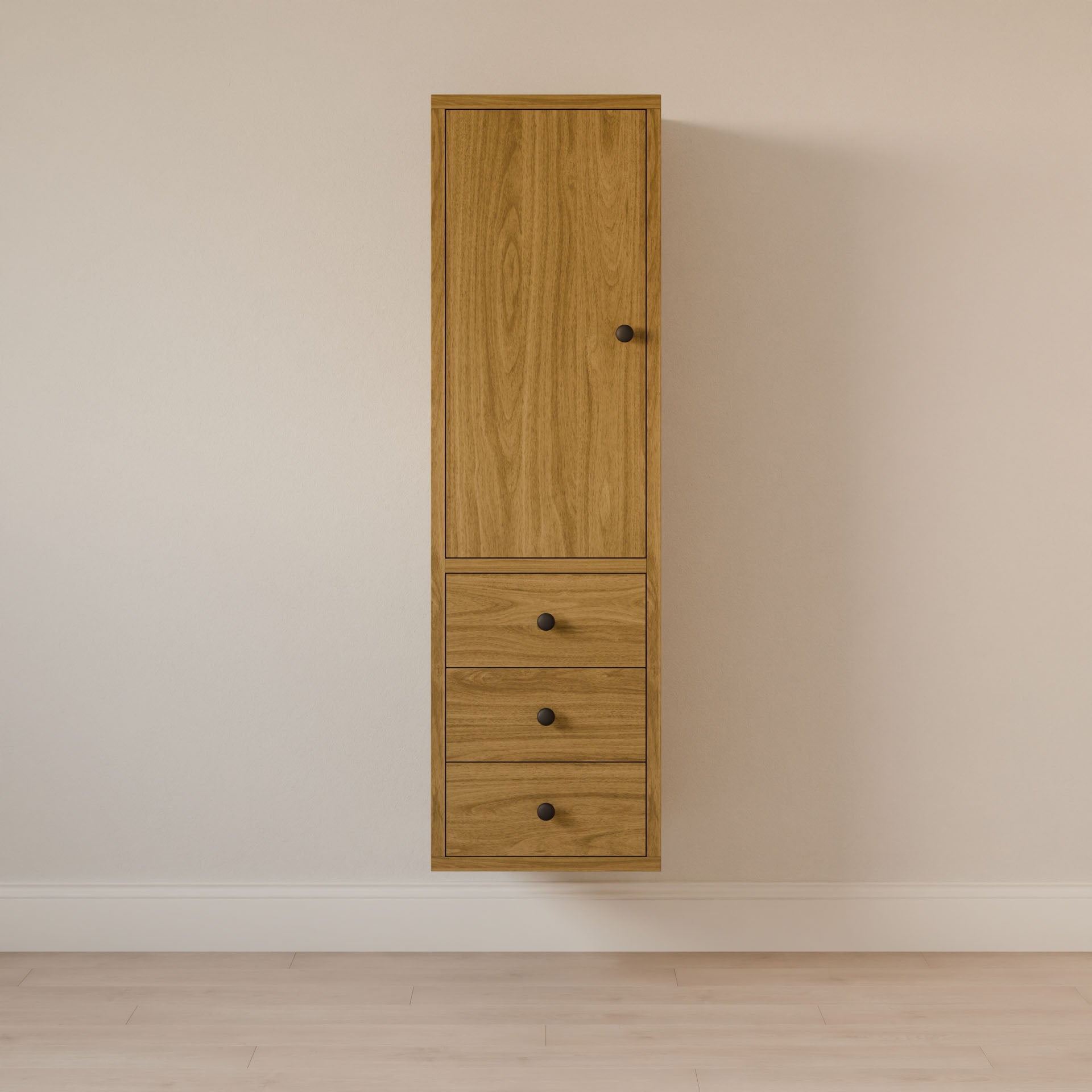Krovel Furniture Co.s Triple Drawer Linen Cabinet in White Oak features a tall, wall-mounted design with a hardwood face frame and light finish set against an off-white wall. It has one top vertical door and three drawers below, each with a black round knob, on a light floor.